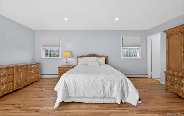 a bedroom with a large bed and wooden floor