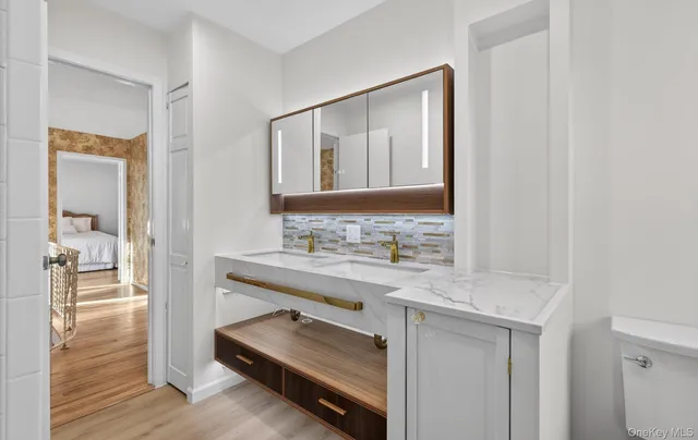 a bathroom with a granite countertop tub sink and mirror