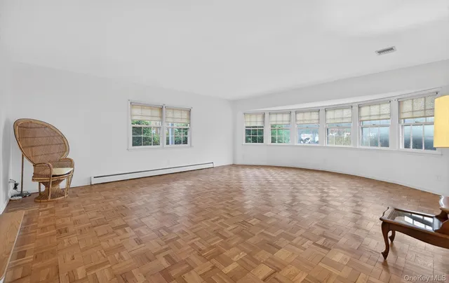 a view of empty room with a window and chair