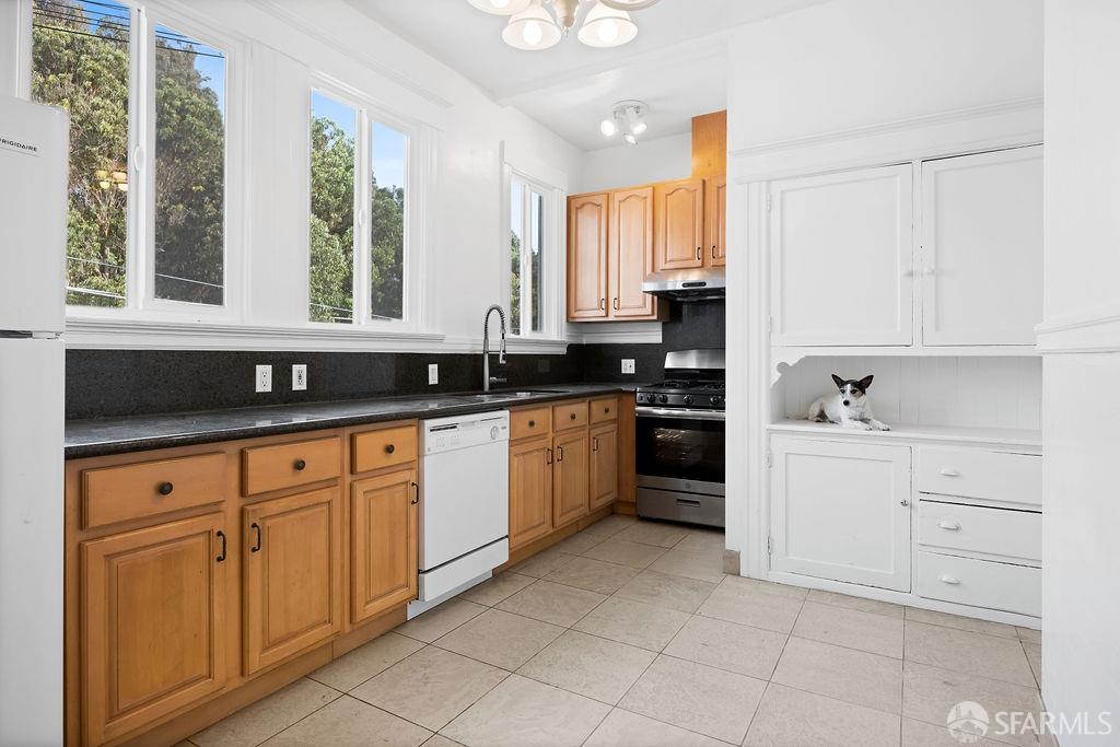 2401 23rd Street San Francisco, CA 94110 - Photo 51 of 76 a kitchen with granite countertop white cabinets white appliances with a sink and a window