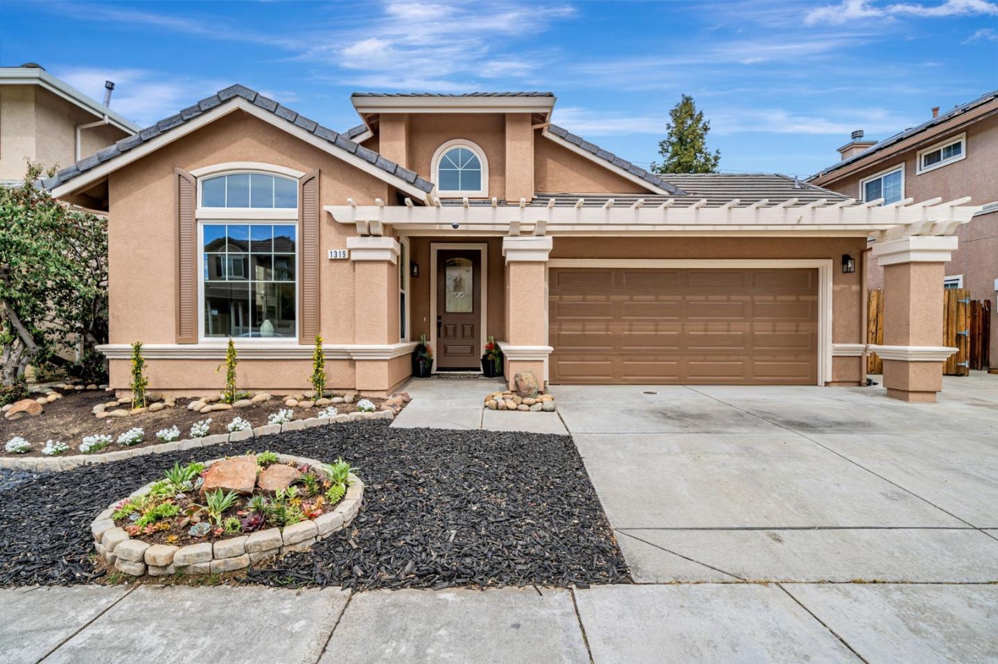 1319 Cherry Blossom Lane Tracy, CA 95377 - Photo 1 of 1 a front view of a house with a garage