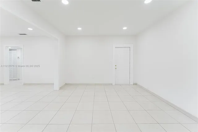 an empty room with white walls and tiles