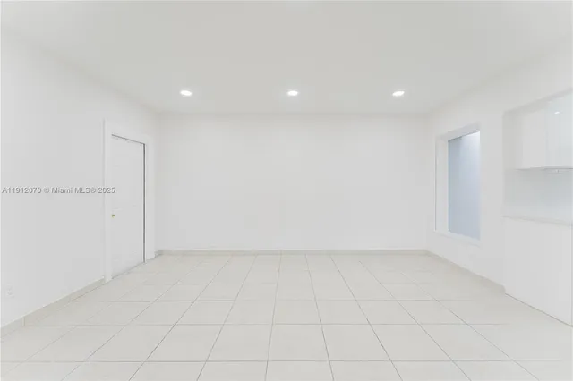 an empty room with white walls and tiles