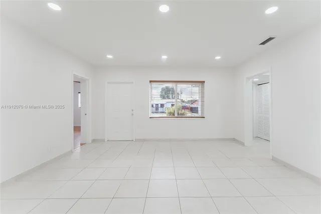 an empty room with white walls and tiles