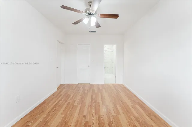 a view of a big room with a ceiling fan and wooden floor