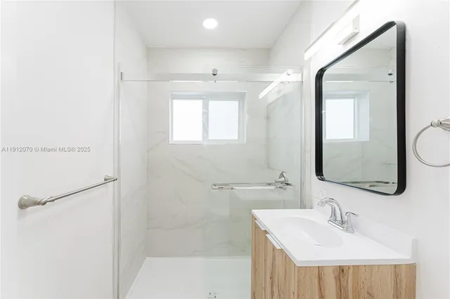 a bathroom with a sink a mirror and a shower