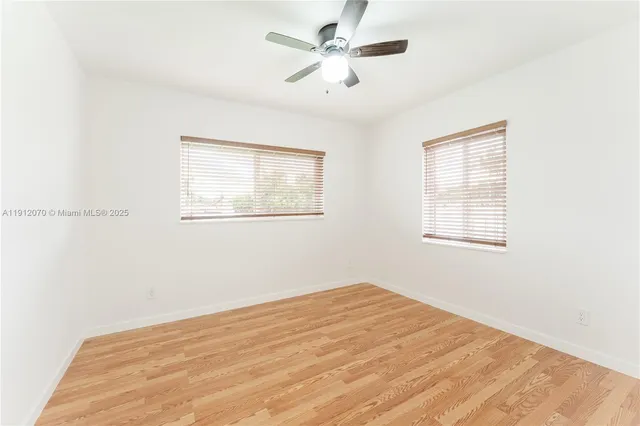 a view of a room with a window and a ceiling fan