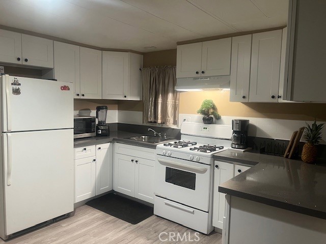 4101 North Paramount Boulevard Pico Rivera, CA 90660 - Photo 8 of 12 a kitchen with a stove white refrigerator and white cabinets