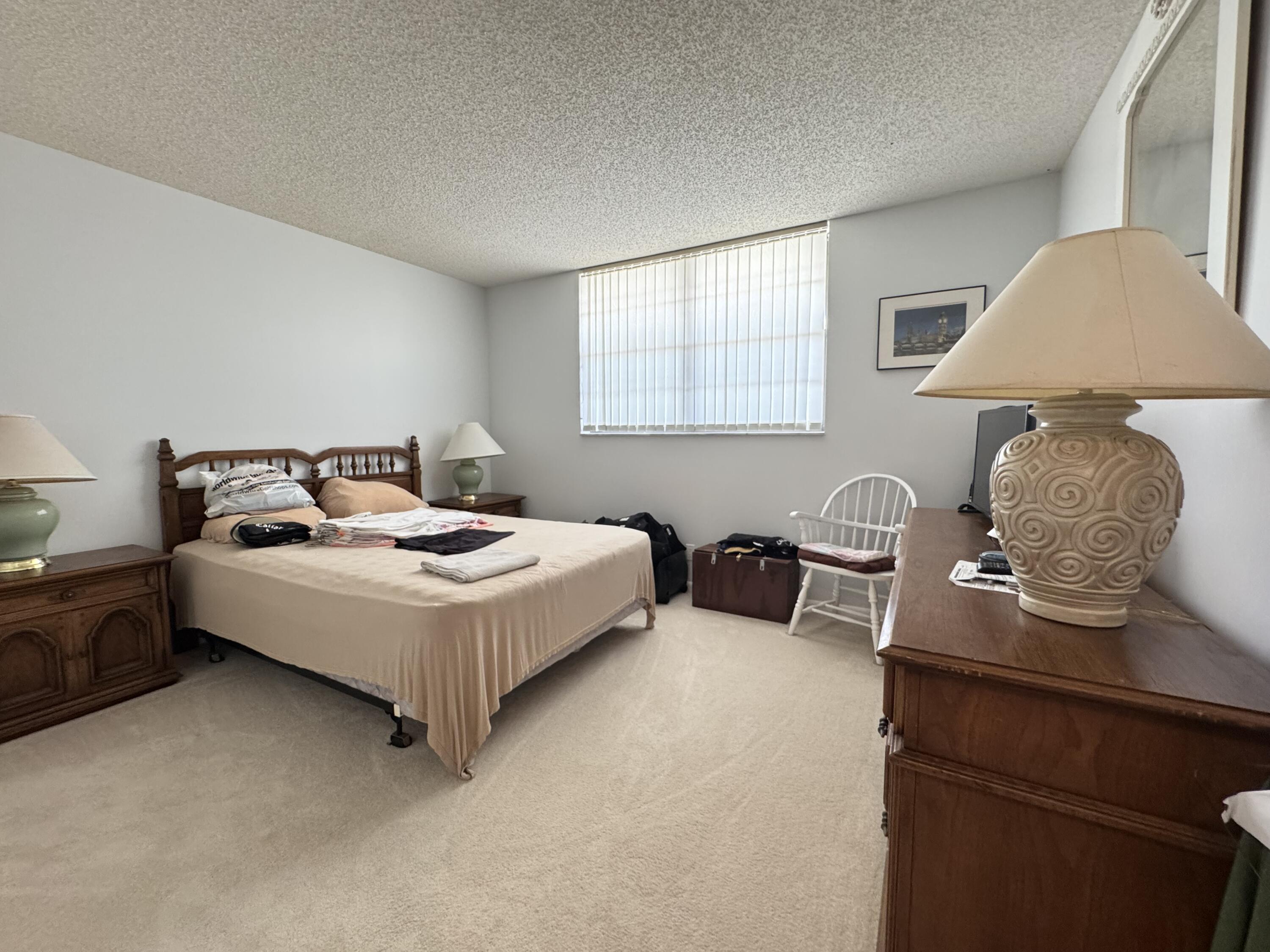 2430 DC Country Club Boulevard, Unit 4072 Deerfield Beach, FL 33442 - Photo 11 of 28 a bedroom with a bed and dresser next to a window