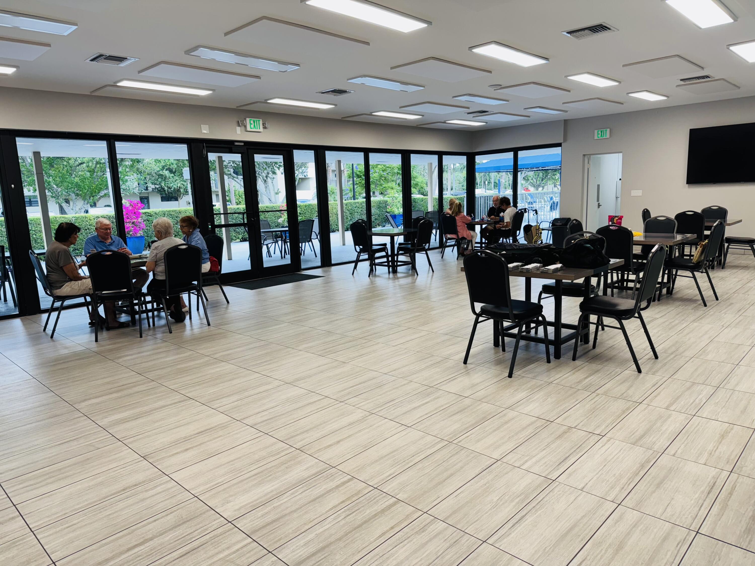 2430 DC Country Club Boulevard, Unit 4072 Deerfield Beach, FL 33442 - Photo 19 of 28 a view of a dining hall with lots of furniture a rug and a large window