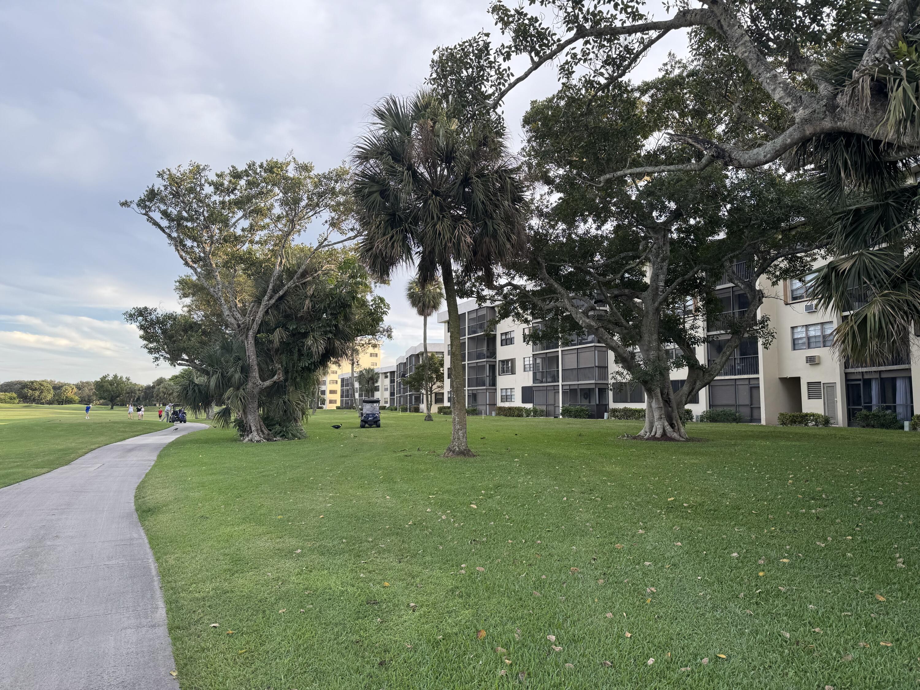 2430 DC Country Club Boulevard, Unit 4072 Deerfield Beach, FL 33442 - Photo 28 of 28 a view of a house with a big yard and large trees