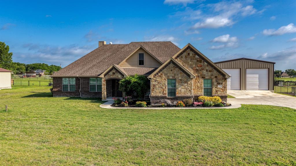 2023 Jo Jones Lane Springtown, TX 76082 - Photo 1 of 25 a front view of a house with a garden and trees