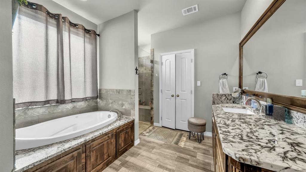 2023 Jo Jones Lane Springtown, TX 76082 - Photo 13 of 25 a spacious bathroom with a granite countertop tub sink and mirror