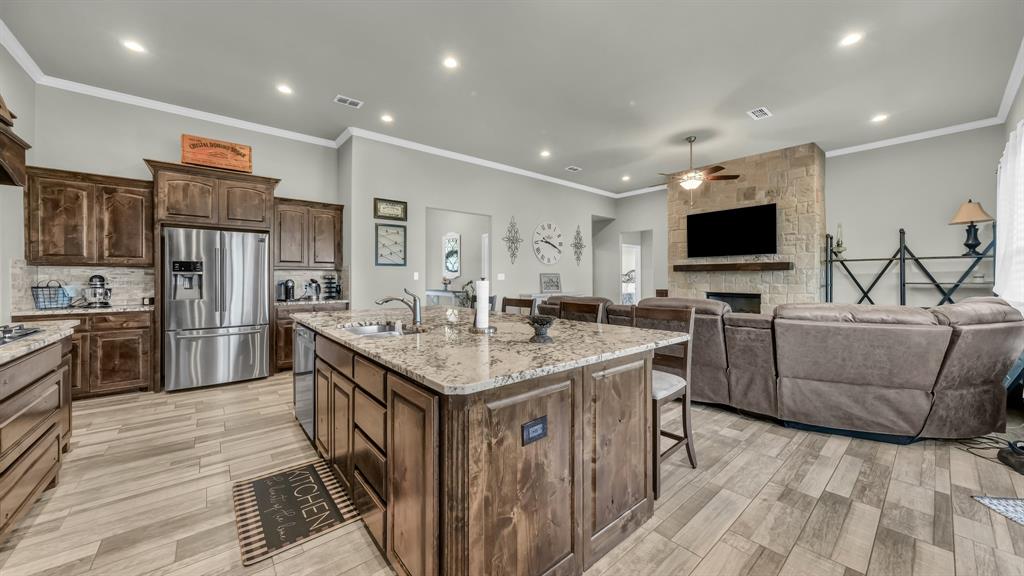 2023 Jo Jones Lane Springtown, TX 76082 - Photo 8 of 25 a kitchen with stainless steel appliances granite countertop a refrigerator a stove a sink dishwasher a oven with white cabinets and wooden floor