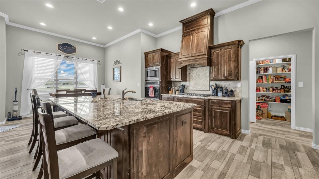 2023 Jo Jones Lane Springtown, TX 76082 - Photo 9 of 25 a kitchen with stainless steel appliances granite countertop a kitchen island a stove and a sink