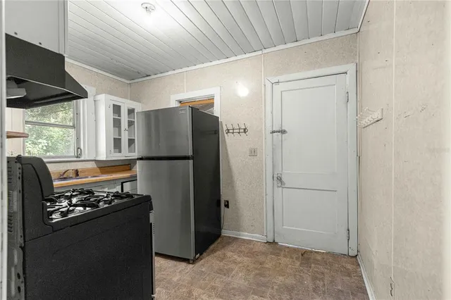 a kitchen with stainless steel appliances granite countertop a refrigerator and a stove