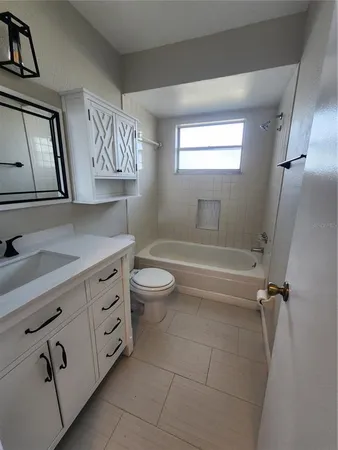 a bathroom with a granite countertop sink a toilet and bathtub