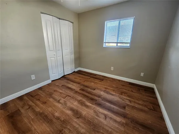 a view of empty room with wooden floor