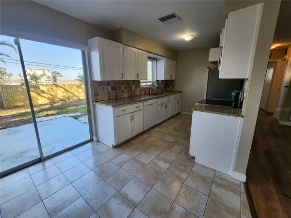 a kitchen with stainless steel appliances granite countertop a refrigerator a stove a sink and a microwave