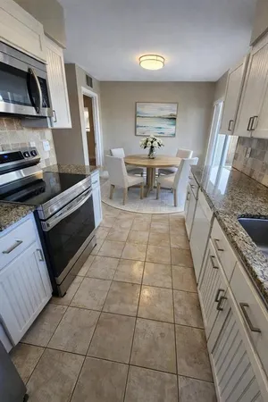 a kitchen with granite countertop a stove a sink and a cabinets