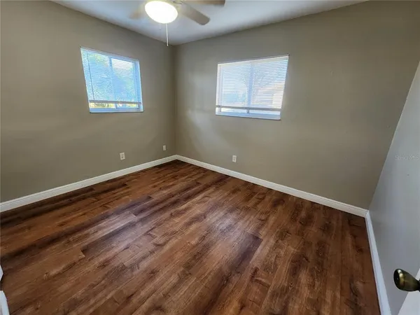 a view of room with wooden floor and windows