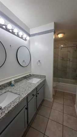 a bathroom with a granite countertop sink a toilet and shower