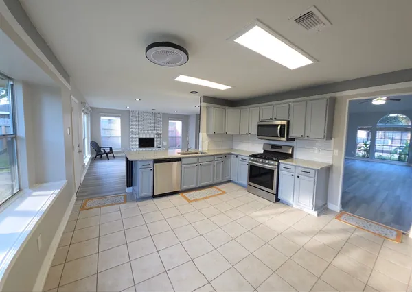 a large kitchen with cabinets and stainless steel appliances