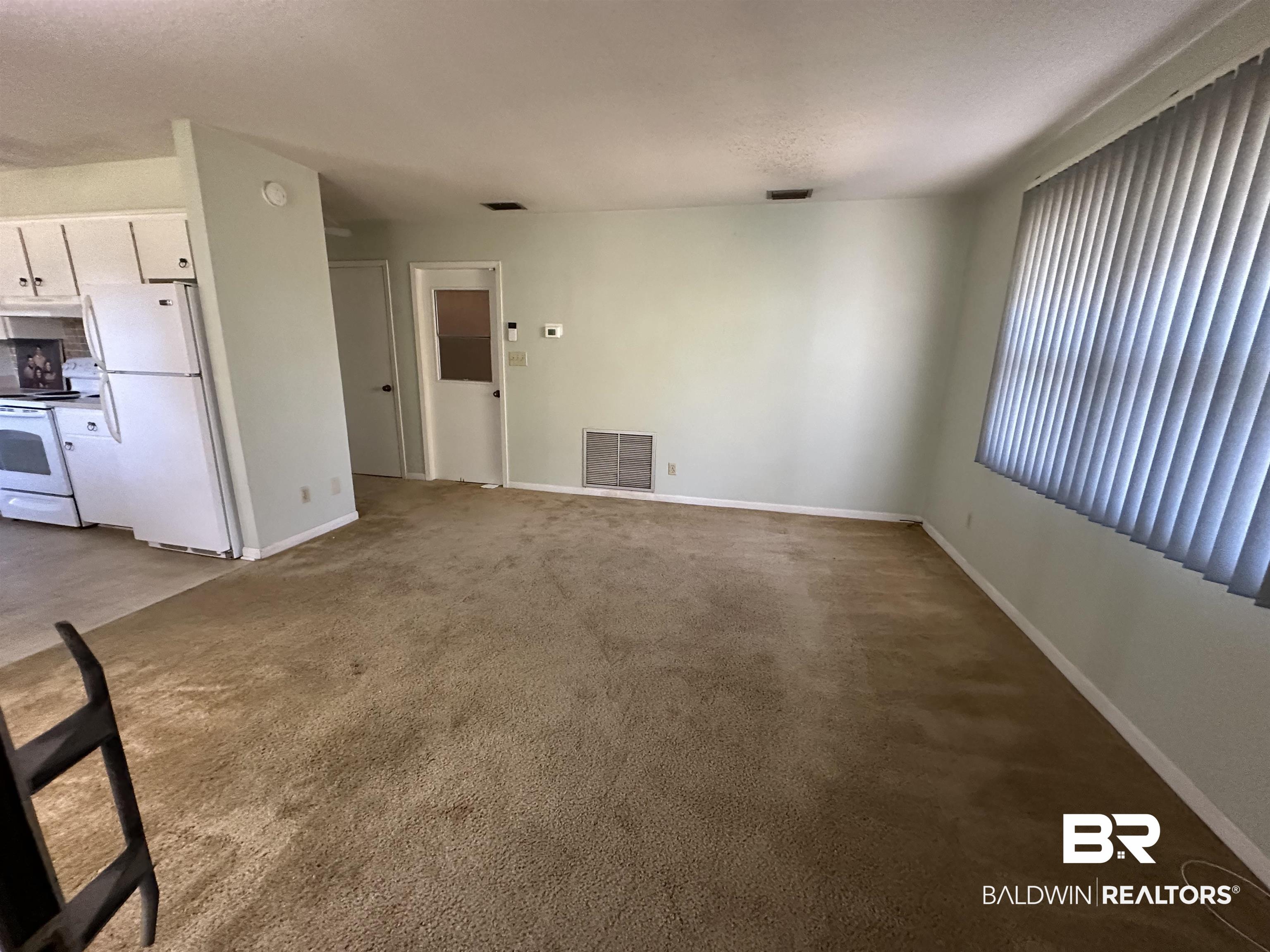 1 Yupon Circle Foley, AL 36535 - Photo 25 of 30 Unfurnished living room featuring baseboards and dark colored carpet