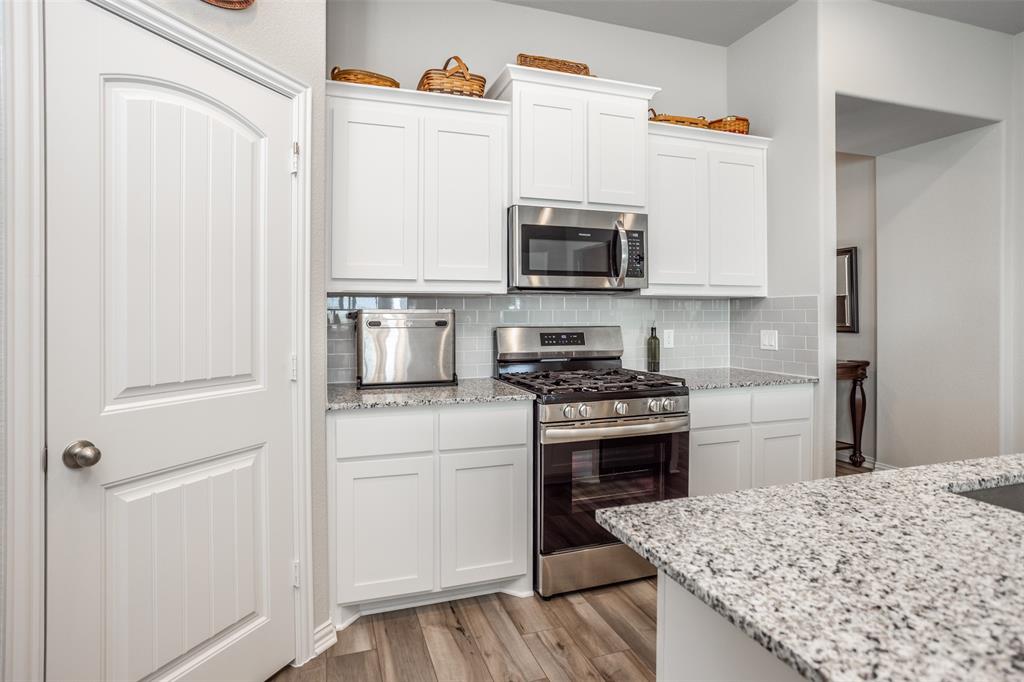 622 Juneau Street Gainesville, TX 76240 - Photo 21 of 39 a kitchen with stainless steel appliances granite countertop a stove a sink and a refrigerator