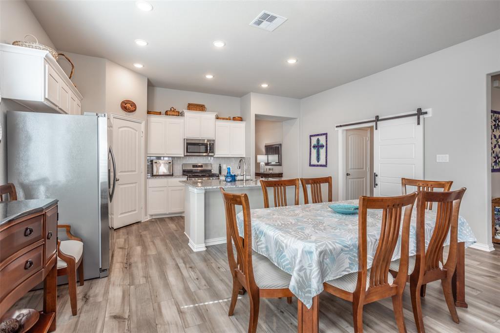622 Juneau Street Gainesville, TX 76240 - Photo 22 of 39 a kitchen with white cabinets and stainless steel appliances
