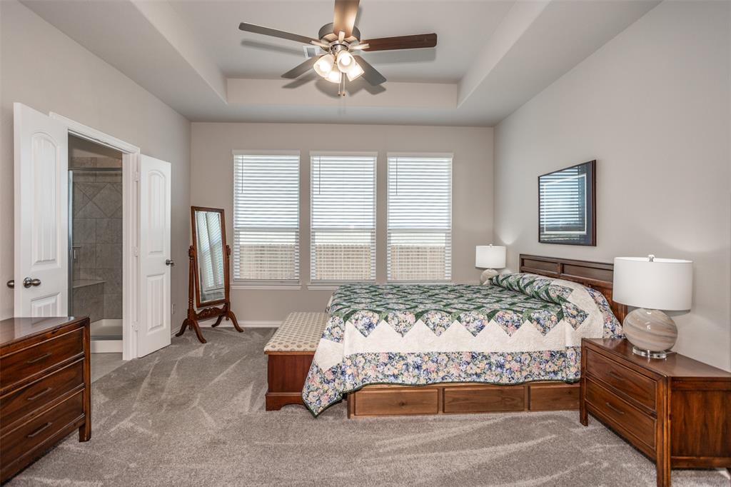 622 Juneau Street Gainesville, TX 76240 - Photo 28 of 39 a bedroom with a bed and a chandelier