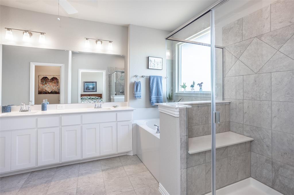 622 Juneau Street Gainesville, TX 76240 - Photo 29 of 39 a spacious bathroom with a double vanity sink a mirror and a shower