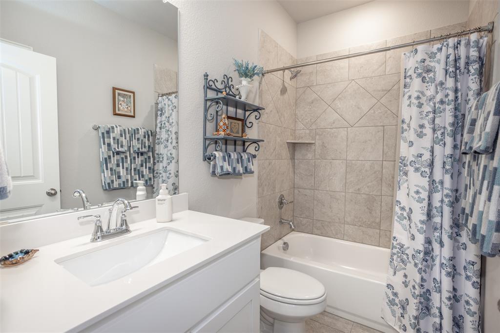 622 Juneau Street Gainesville, TX 76240 - Photo 35 of 39 a bathroom with a granite countertop sink a toilet and shower