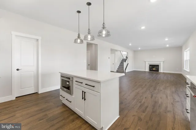 a view of empty room with wooden floor and windows