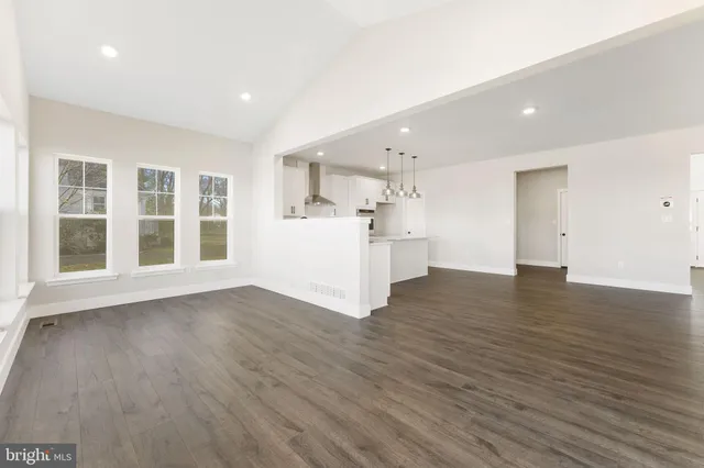 a kitchen with white cabinets stainless steel appliances and wooden floor