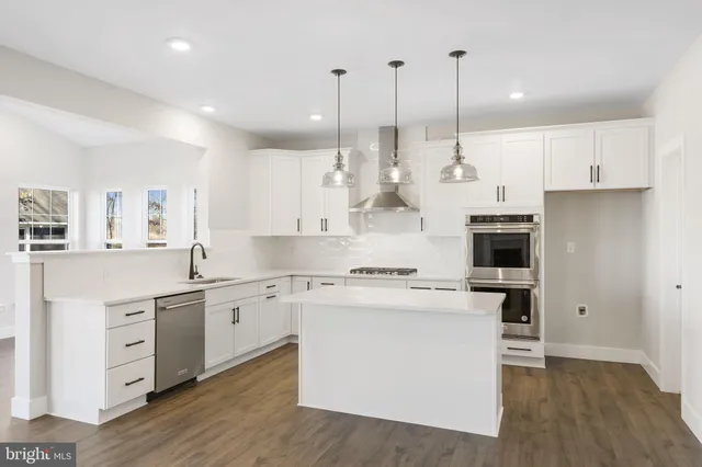 a kitchen with white cabinets and appliances