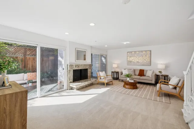 a living room with furniture large window and a fireplace
