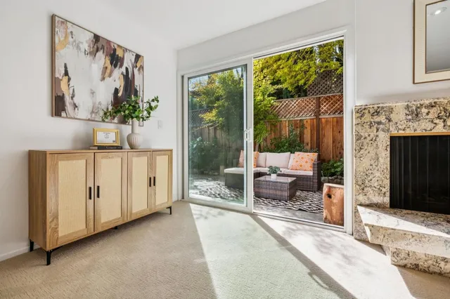 a living room with furniture a fireplace and a large window