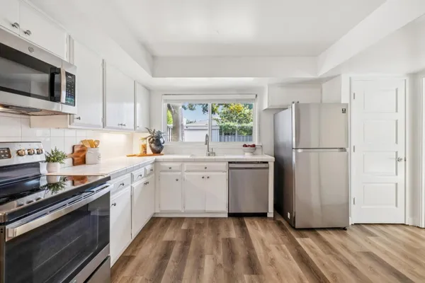 a kitchen with stainless steel appliances granite countertop a refrigerator sink and stove