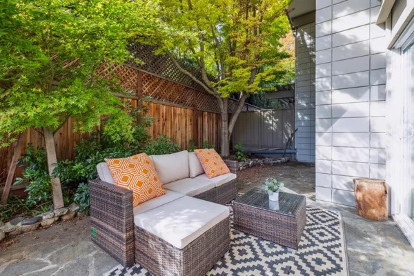 a view of backyard with outdoor seating and trees
