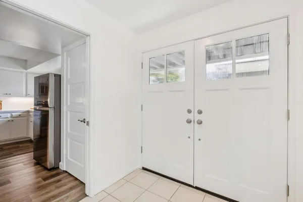 a view of a hallway with wooden floor and a cabinet