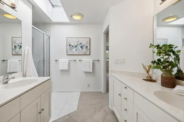 a spacious bathroom with a shower sink mirror and