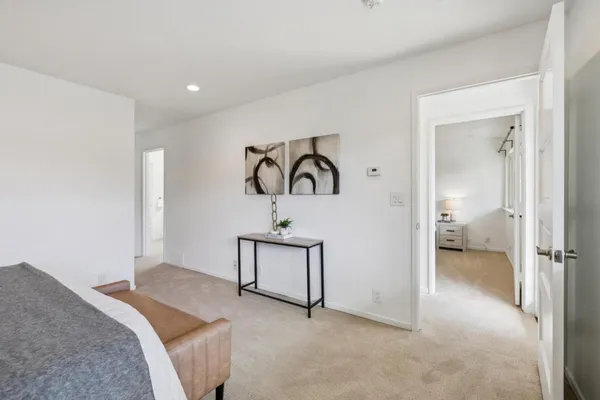 a bedroom with bed and a painting on the wall