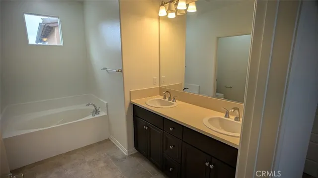 a bathroom with a tub sink and mirror