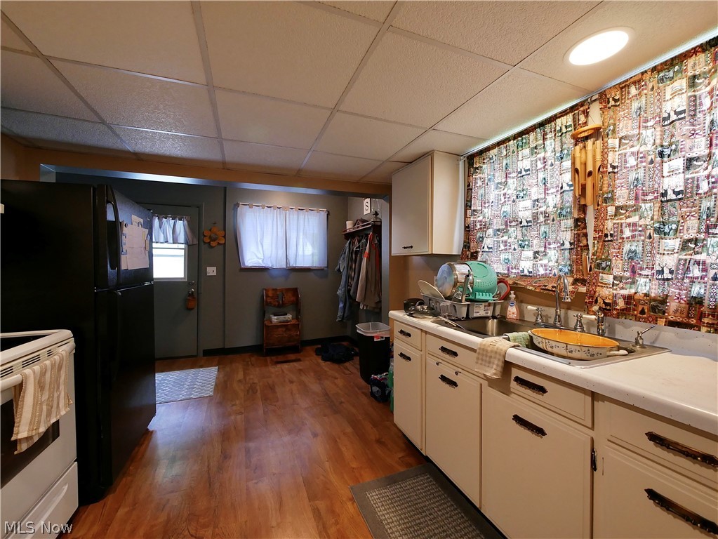 75450 Fair Road Freeport, OH 43973 - Photo 41 of 45 Kitchen with white cabinets, stove, hardwood / wood-style flooring, and a drop ceiling