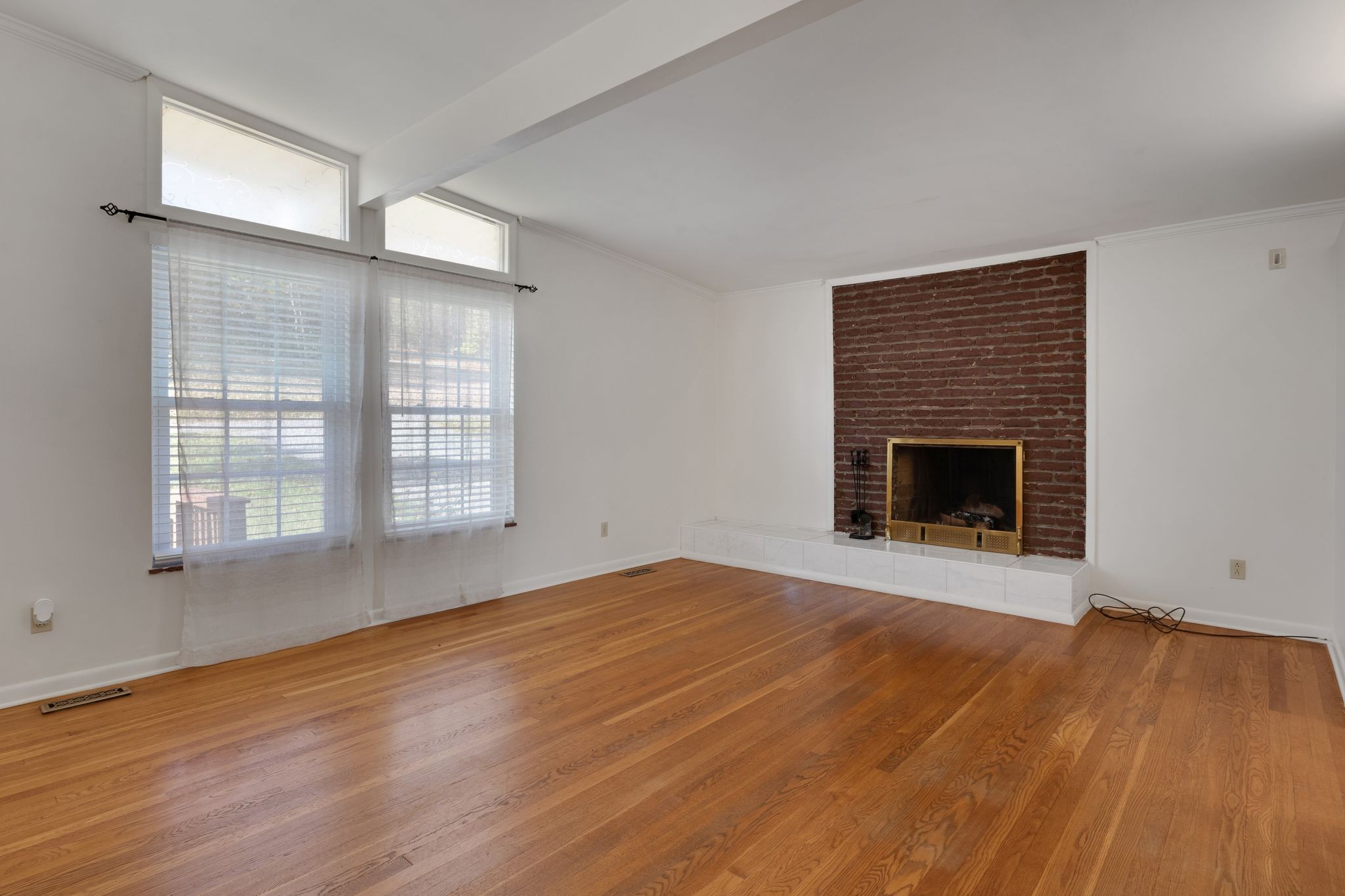 101 Locust Lane Oak Ridge, TN 37830 - Photo 3 of 33 an empty room with wooden floor fireplace and windows
