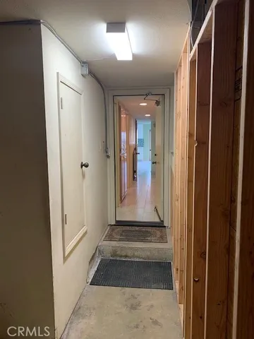 a view of a hallway with wooden floor and a livingroom with a bathroom