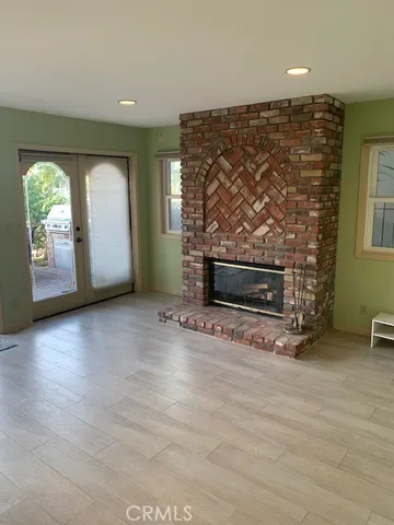 an empty room with windows and fireplace