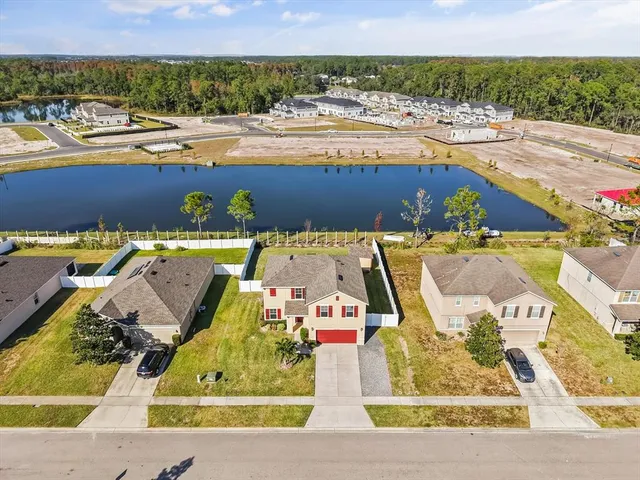 an aerial view of a house with a yard and lake view