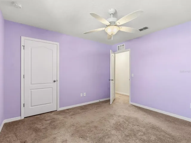 an empty room with fan and window